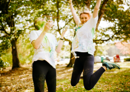Two girls jumping during the Colour run